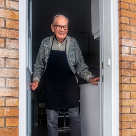 papi au pas de sa porte souriant pour le service à domicile