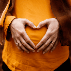 mains en forme de cœur sur un ventre enceinte
