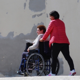 femme poussant une mamie en fauteuil roulant